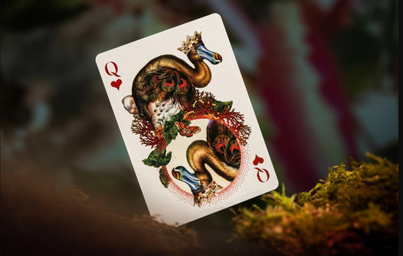 A beautifully illustrated playing card featuring a stylized depiction of an extinct animal. The card showcases intricate designs with vibrant colors and detailed artwork, highlighting the theme of extinct species. The card is leaning against mossy ground, adding a natural element to the imagery.