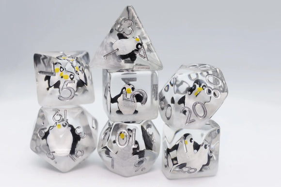 A set of six intricately designed Baby Penguin dice featuring cute penguin illustrations encased in a transparent resin material. The dice include various shapes, such as a tetrahedron and cube, with clear numerical engravings, making them perfect for tabletop games. The playful penguin designs add a fun and whimsical touch to gaming sessions.