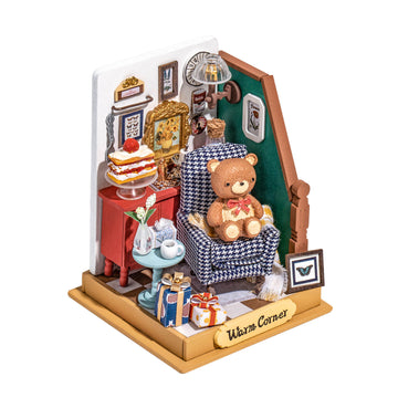 A cozy DIY holiday living room scene designed by Robotime, featuring a plush teddy bear sitting on a patterned chair. The setting includes a decorated side table with a cake, a vase of flowers, and beautifully wrapped gifts. The walls are adorned with various frames and a lamp adds warmth to this inviting atmosphere.