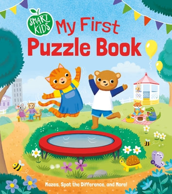 Cover of 'Smart Kids: My First Puzzle Book' featuring a cheerful cat and bear jumping on a trampoline in a colorful park setting. The background includes playful elements like flowers, bees, and a festive atmosphere with banners and a carnival booth, emphasizing puzzle activities like mazes and spotting differences.