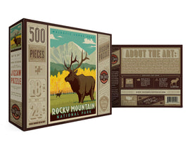 Rocky Mountain Jigsaw Puzzle by True South Puzzles featuring a picturesque scene of Longs Peak and an elk. The puzzle contains 500 pieces and measures 18 x 24 inches, showcasing vibrant autumn colors. The box includes detailed information about the artwork and the Rocky Mountain National Park.