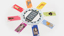 Kariba game by Helvetiq displayed with colorful animal cards arranged in a circular fashion around a central puzzle piece holder. The cards feature playful, geometrically designed animals and numbers, creating an engaging and family-friendly gaming experience.