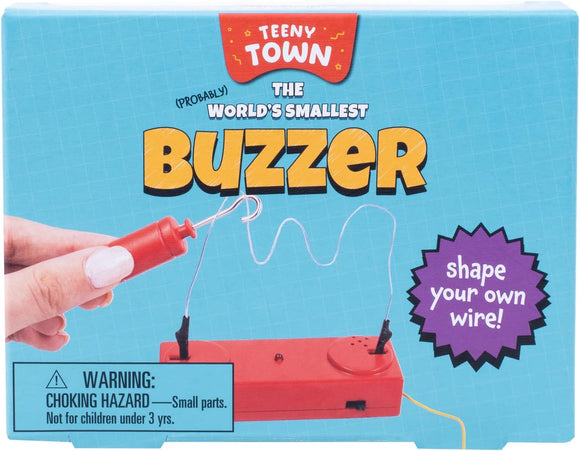 Teeny Town Buzzer Game by Fizz Creations Inc. features a bright red device with a wire and buzzer. The packaging highlights the fun text 'shape your own wire!' along with a warning for small parts. Ideal for creative play and challenges, this game is designed for both kids and adults, encouraging problem-solving and fine motor skills.