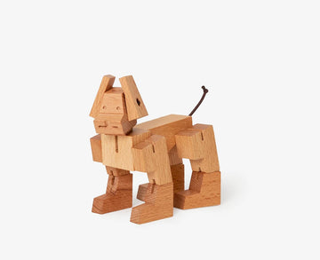 Cubebot Milo Micro in natural wood finish, designed as a mechanical puzzle. This charming wooden figure resembles a dog and features movable limbs, showcasing craftsmanship and creativity. Ideal for both kids and adults who enjoy hands-on activities.
