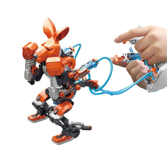 A DIY kit featuring hydraulic boxing bots designed by Thames & Kosmos. The image shows an orange robot with movable limbs being operated by a hand using a control system, highlighting its interactive nature and engineering features.