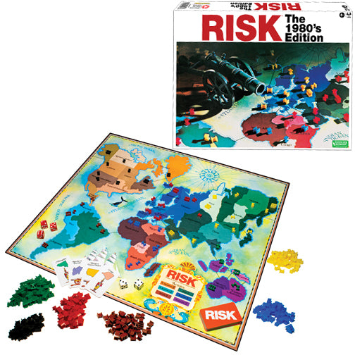 The 1980's Edition of the Risk board game by Winning Moves, featuring a detailed map of the world game board, colorful plastic army pieces in various colors including red, yellow, green, and black, dice, and risk cards. The game box is shown in the background, adorned with the title 'RISK' prominently displayed.