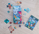 An Ocean Creatures Reversible Jigsaw puzzle by Boxer, featuring colorful illustrations. The box displays vibrant scenes of sea creatures, while scattered jigsaw pieces include various marine life. Ideal for children and puzzle enthusiasts alike, this jigsaw can be flipped for two different images, enhancing fun and engagement.