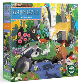 Eeboo Woodland jigsaw puzzle box featuring a vibrant illustration of woodland animals including a raccoon, deer, bear, rabbit, and a variety of colorful plants. The puzzle contains 64 pieces and is suitable for ages 5 and up. The artwork showcases a lively natural scene with a river, trees, and flowers, promoting creativity and learning.