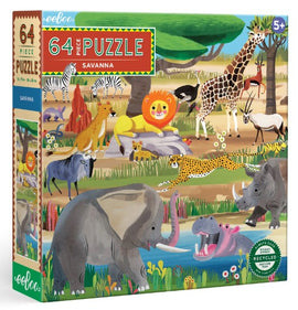 A colorful jigsaw puzzle box featuring a vibrant savanna scene with various animals, including a lion, giraffe, elephant, and zebra. The puzzle contains 64 pieces and is suitable for ages 5 and up. It emphasizes eco-friendly materials with a 'recycled' label.