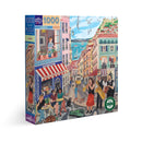 Eeboo's 'Lisbon' jigsaw puzzle featuring a vibrant street scene from Lisbon. The puzzle box displays colorful illustrations of musicians, cafes, and seaside views, inviting puzzlers into the charming culture of the city. With 1000 pieces, it offers a delightful challenge for adults and families alike.
