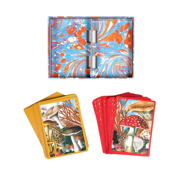 A colorful set of Mushroom Playing Cards by Eeboo showcasing various mushroom illustrations. The cards are displayed with a vibrant case featuring a marbled design in orange and blue. There are stacks of yellow and red cards, each showcasing unique mushroom artwork.