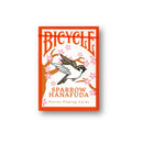 A vibrant deck of Bicycle Sparrow Hanafuda cards featuring a sparrow illustration surrounded by cherry blossoms. The packaging is bright orange with stylish typography, indicating 'Sparrow Hanafuda' and 'Fusion Playing Cards' from US Playing Card Co.