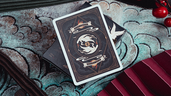 Pine Crane Playing Cards by Solokid displayed on a colorful textured background. The face of the card features elegant crane illustrations surrounded by ornate design elements, exuding a sense of artistic charm.