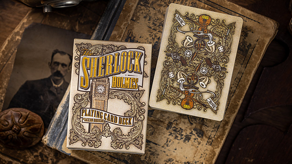A beautifully designed deck of Sherlock Holmes playing cards by Kings Wild. The box features intricate illustrations and vintage typography, showcasing iconic symbols associated with the famous detective. The deck includes detailed card backs and an elegant overall aesthetic, perfect for fans of Sherlock Holmes and card games alike.