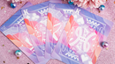 A set of Solokid Rainbow Dream Playing Cards by Kings Wild, featuring beautifully designed cards with a gradient of pink, purple, and blue colors, displayed on a sparkly background. The faces of cards elegantly showcase kings with ornate illustrations, making them perfect for both play and display.