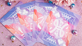 A set of Solokid Rainbow Dream Playing Cards by Kings Wild, featuring beautifully designed cards with a gradient of pink, purple, and blue colors, displayed on a sparkly background. The faces of cards elegantly showcase kings with ornate illustrations, making them perfect for both play and display.