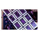 The Constellation Majestic Playing Cards on a dark blue surface, featuring intricate designs in purple and black. The cards are spread out, showcasing unique illustrations and heavenly motifs. Surrounding the cards are dried purple petals, adding a touch of elegance to the arrangement.