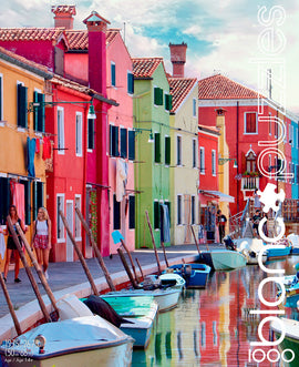 A vibrant jigsaw puzzle featuring the picturesque Canals of Burano, Italy, showcasing colorful houses along the waterfront. The scene includes women walking beside the canal and boats docked along the shore, reflecting the beautiful colors of the buildings. This image captures the essence of Italy's charming architecture and tranquil waterways.