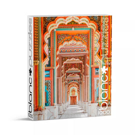 A beautifully designed jigsaw puzzle box featuring the Patrika Gate from Blanc Puzzles. The vibrant colors showcase intricate architectural details of the gate, set against a backdrop of ornate designs. This 1000-piece puzzle promises a challenging and rewarding experience for puzzle enthusiasts.