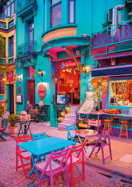 A vibrant jigsaw puzzle depicting the colorful Sultanahmet neighborhood in Istanbul. The image showcases a lively street scene with charming cafes, elegantly designed buildings, and outdoor seating, creating a picturesque atmosphere filled with hues of blue and pink.