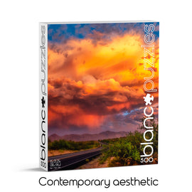 The jigsaw puzzle titled 'Desert Clouds, Arizona' by Blanc Puzzles showcases a stunning image of vibrant, multicolored clouds over a desert landscape. The box is designed with a contemporary aesthetic, featuring a clear and appealing photo. This 500-piece puzzle is perfect for both puzzle enthusiasts and casual hobbyists, bringing the beauty of nature into your home.