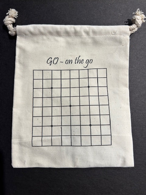A small, cream-colored canvas bag featuring 'GO - on the go' printed at the top and a grid design below, suitable for carrying a portable Go game.