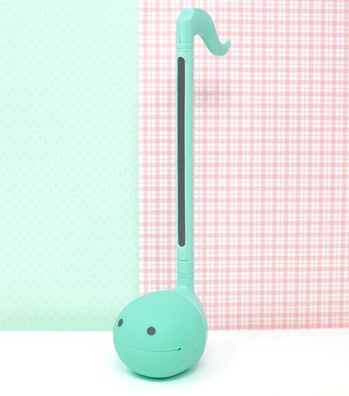 The Otamatone Mint by Hamee is a whimsical musical instrument designed to look like a smiling character. It features a rounded body in a mint green color, a long neck, and an expressive face, encouraging fun and creativity in music-making. Ideal for kids and music enthusiasts alike, the Otamatone combines playfulness with musical exploration.