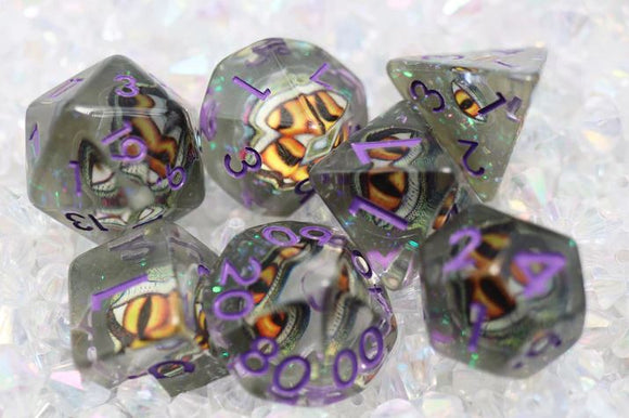 A stunning Venom Dragon Eye RPG Dice Set featuring seven polyhedral dice in shades of translucent gray and vivid orange accents. Each die displays intricate dragon eye imagery, complemented by vibrant purple numbers. Perfect for tabletop gaming and RPG enthusiasts, these dice add a unique flair to your gaming sessions.