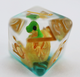 Close-up of a green dragon hatchling RPG dice. The die features a vibrant green dragon-like creature encased within a transparent cube, with golden numbers visible on the sides.