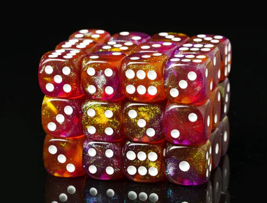 A vibrant, 12-piece set of D6 dice featuring an autumnal design with hues of orange, yellow, and glitter. Each die has white pips and a glossy finish, arranged in a stack showcasing their colorful patterns against a black reflective surface.