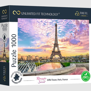 Trefl jigsaw puzzle featuring a picturesque sunset view of the Eiffel Tower in Paris, France. The image displays vibrant colors in the sky and a serene reflection in the water, creating a romantic atmosphere. The puzzle box includes details about its unique unlimited fit technology and eco-friendly materials.