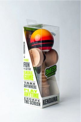 The Double Stripe Fade Red Kendama by Sweets Kendamas displayed in its packaging. The kendama features a red and black striped ball and a natural wood handle. The packaging emphasizes fun, skill-based gameplay, making it a great portable option for active play.