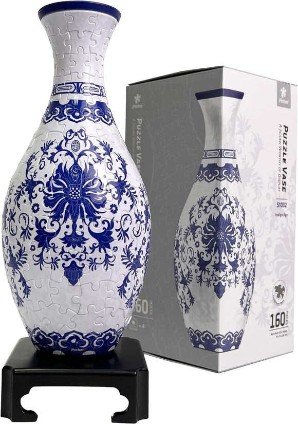 Pintoo P- Vase S1032 Indigo Age jigsaw puzzle featuring a beautifully designed vase with intricate blue and white floral patterns, displayed on a black stand. The puzzle comes in a box, showcasing its 160 pieces and recommended for ages 4 and up.