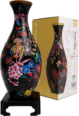 A vibrant jigsaw puzzle depicting an elegant floral vase design. The vase features intricate patterns of colorful flowers on a black background, resting on a stand. The puzzle comes in a decorative box labeled 'Pintoo Puzzle Vase - S1031 Elegant Floral Print' with 160 pieces.