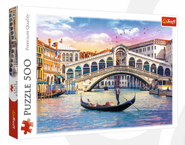 Trefl jigsaw puzzle featuring the Rialto Bridge in Venice, showcasing vibrant colors of the sunset and a gondola in the foreground. The picturesque scene captures the beauty of Venetian architecture and canals.