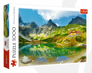 A jigsaw puzzle by Trefl featuring a scenic landscape titled 'Shelter Over Green Pond'. The image showcases a tranquil green pond surrounded by majestic mountains and a charming yellow house, under a bright blue sky with a few clouds. This 1000-piece puzzle captures the beauty of nature, making it perfect for puzzle enthusiasts and nature lovers alike.
