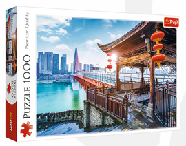 Trefl 1000-piece jigsaw puzzle featuring a stunning view of Chongqing, China, showcasing the city's bridge and skyline with a traditional pavilion in the foreground. The image captures vibrant colors and intricate details, making it a beautiful challenge for puzzle enthusiasts.