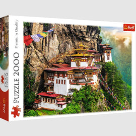 A jigsaw puzzle box featuring the stunning Tiger's Nest monastery in Bhutan. The image highlights the intricate architecture of the monastery perched on a cliff, surrounded by lush greenery and colorful prayer flags. This 2000-piece puzzle by Trefl promises hours of challenging fun and detailed craftsmanship.
