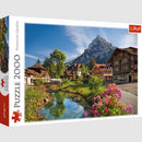 Jigsaw puzzle titled 'Alps in the Summer' by Trefl, featuring a stunning landscape of the Alps with vibrant flowers, a clear stream, and traditional wooden chalets under a bright blue sky. This 2000-piece puzzle captures the scenic beauty of summer in the Alps.
