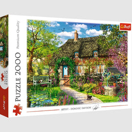 Trefl Country Cottage 2000 piece jigsaw puzzle featuring a beautifully illustrated scene of a quaint cottage surrounded by lush greenery and colorful flowers, set against a bright sky. The intricate details and vibrant colors make this puzzle a delightful challenge for puzzle enthusiasts.