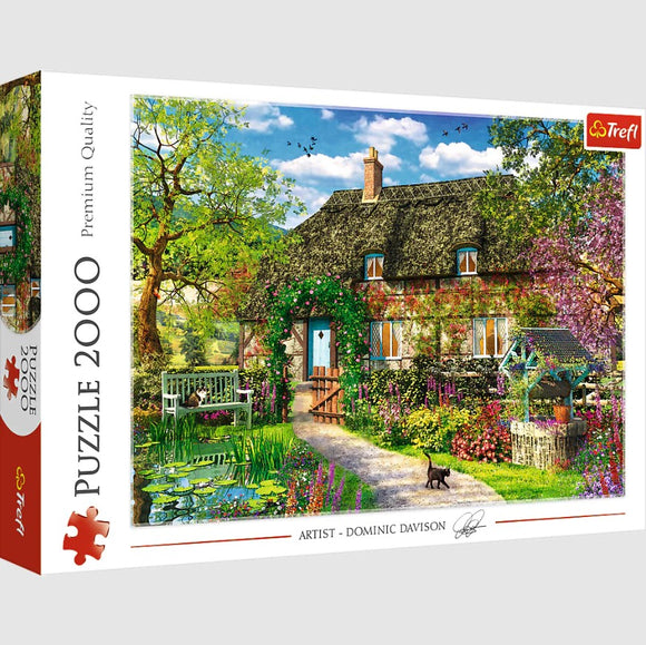 Trefl Country Cottage 2000 piece jigsaw puzzle featuring a beautifully illustrated scene of a quaint cottage surrounded by lush greenery and colorful flowers, set against a bright sky. The intricate details and vibrant colors make this puzzle a delightful challenge for puzzle enthusiasts.