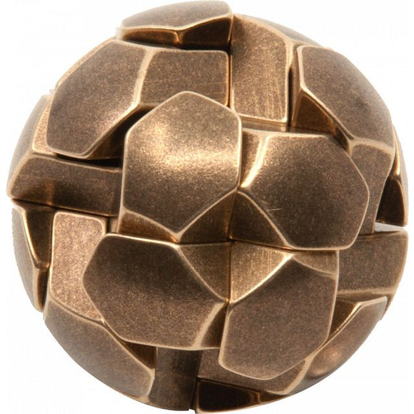 The Gob Stopper by Two Brass Monkeys is a metallic mechanical puzzle resembling a spherical shape made up of interlocking geometric pieces. Its shiny bronze finish adds an elegant touch, making it a captivating conversation starter and a challenging brain teaser.