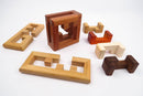 An assortment of beautifully crafted wooden mechanical puzzles, featuring various shapes and sizes. The center piece is a larger, intricately designed cube, surrounded by smaller interlocking pieces in different wood tones including light beige, rich reddish-brown, and dark brown. This collection showcases the elegance and challenge of mechanical puzzles, perfect for enhancing problem-solving skills and providing hours of entertainment.