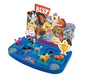 Doggy Showdown mechanical puzzle by MindWare featuring colorful cartoon dog figurines and a vibrant game board. The board displays several playful dog characters, a trophy, and the word 'BEST' prominently at the back, inviting players to engage in a fun challenge that enhances problem-solving skills.