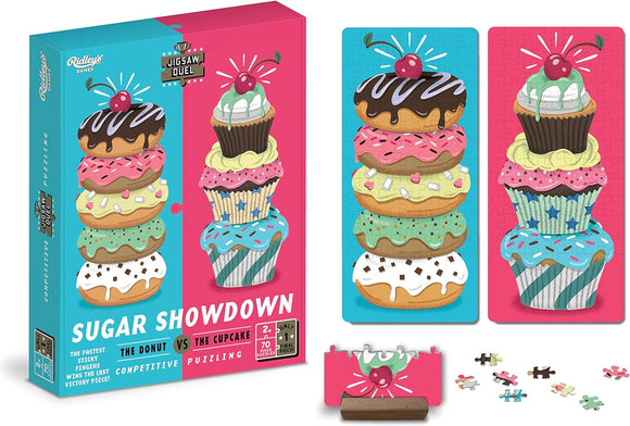 The Jigsaw Duel Sugar Showdown puzzle by Ridley's Games features colorful and delicious-looking cupcakes stacked atop donuts. The packaging shows two completed segments of the puzzle, one with a stacked donut topped with chocolate icing and another with a cheerful cupcake. Accompanied by small puzzle pieces and a unique finishing piece to indicate victory in a competitive puzzling challenge. Perfect for players aged 2 and up.