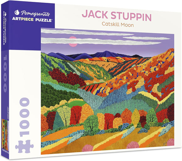 The Catskill Moon jigsaw puzzle by Pomegranate features a vibrant and colorful landscape illustration by Jack Stuppin. The artwork depicts rolling hills adorned with trees in autumn hues of red, orange, yellow, and green, set against a backdrop of mountains and a soft purple sky suggested by a rising or setting moon. The puzzle contains 1000 pieces.