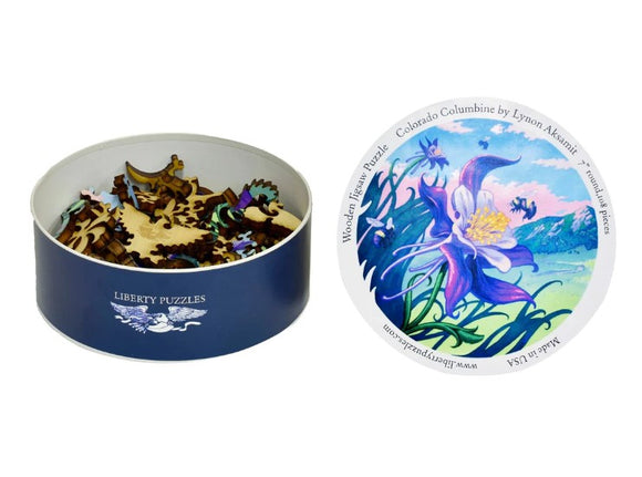 Colorado Columbine jigsaw puzzle by Liberty Puzzles featuring vibrant artwork of the Colorado Columbine flower, displayed in a round tin. The tin shows colorful puzzle pieces and the design illustrates a scenic background with mountains and flowers, emphasizing nature's beauty.