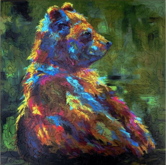 A vibrant jigsaw puzzle titled 'Baby Steps' featuring an impressionistic bear. The puzzle showcases rich colors of orange, blue, and green, creating a striking visual of the bear in a serene background. The piece shape adds an engaging twist to the traditional puzzle experience.