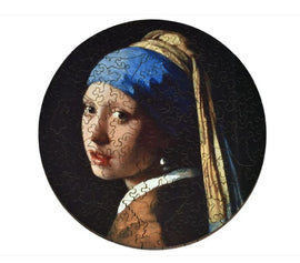 A round jigsaw puzzle featuring the famous painting 'Girl with a Pearl Earring' by Johannes Vermeer. The image showcases the young girl with a blue and yellow headscarf, turned slightly to her left, her captivating gaze directed toward the viewer. The puzzle pieces are intricately shaped, providing a unique challenge for puzzle enthusiasts.