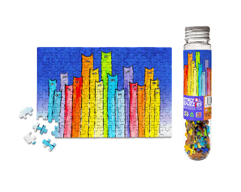 The jigsaw puzzle titled 'A Pride of Cats' features a colorful array of tall, cartoon-like cats standing together against a vibrant blue backdrop. The completed puzzle is shown next to a clear cylindrical container filled with many small, colorful puzzle pieces, some of which are spread out beside the puzzle. The puzzle is designed for all ages, perfect for cat lovers and puzzle enthusiasts alike.